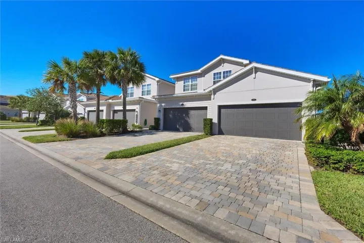 View of front of home with stucco siding and decorative driveway