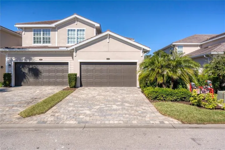 View of front of house featuring decorative driveway and stucco siding