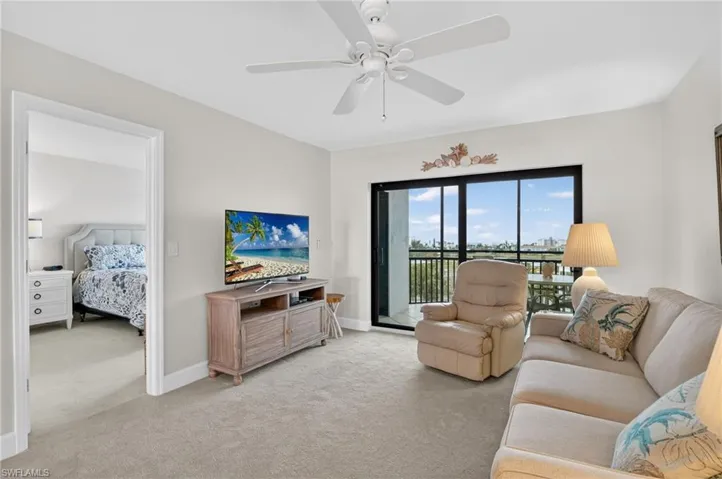Living room with light colored carpet and a ceiling fan
