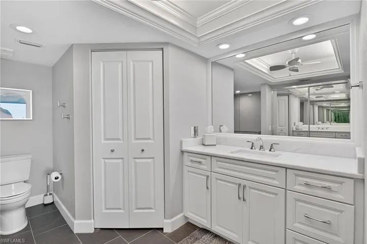 Full bathroom with a closet, vanity, recessed lighting, ornamental molding, and dark tile patterned flooring