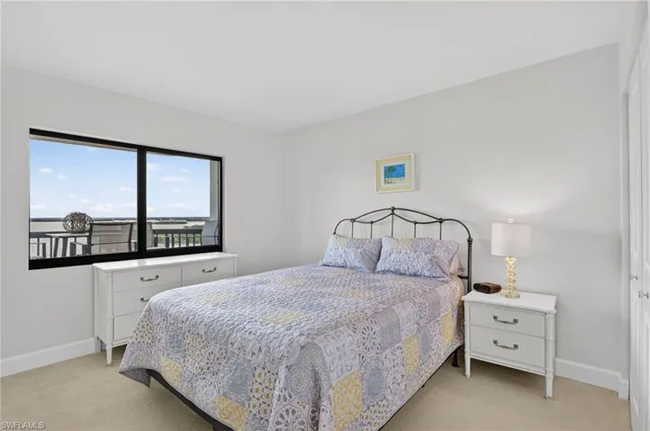 Bedroom featuring baseboards and light carpet