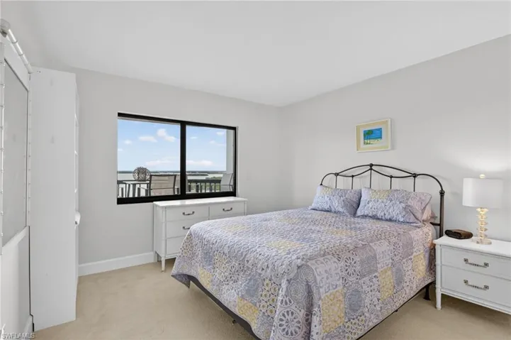Bedroom with light colored carpet and baseboards