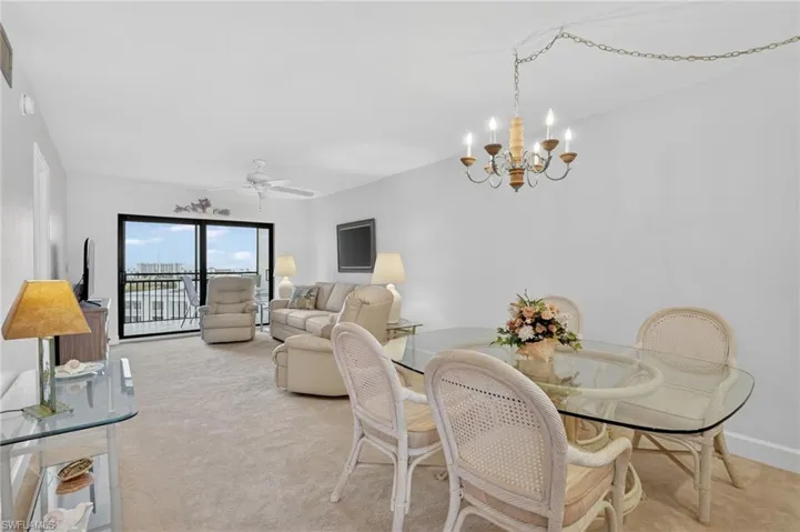 Dining space featuring suspended lighting, ceiling fan, and light colored carpet