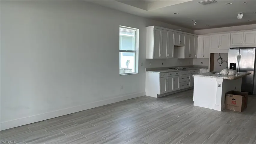 Kitchen and great room area with 36" gas cooktop, Whirlpool 36" side-by-side, wall oven and wall microwave with glass touch control. Quartz countertops and soft-close cabinets and drawers