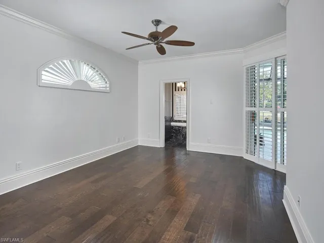 Primary Bedroom with dark hard wood floors and walk-in closet