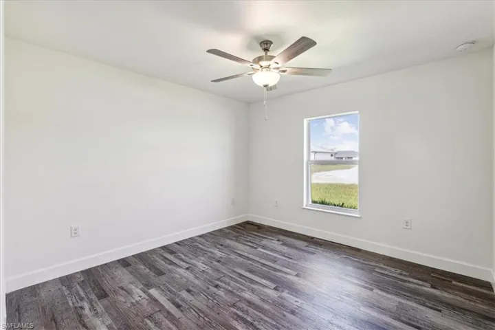 Spare room with ceiling fan and dark hardwood / wood-style flooring