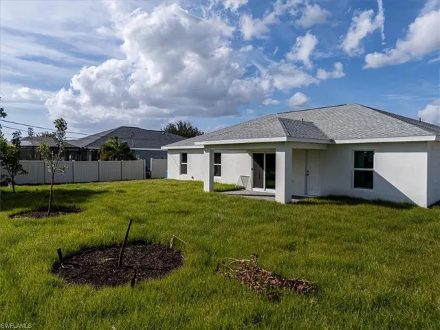 Back of house featuring a lawn