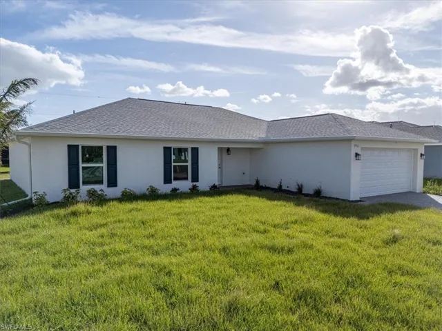 Single story home featuring a front lawn and a garage