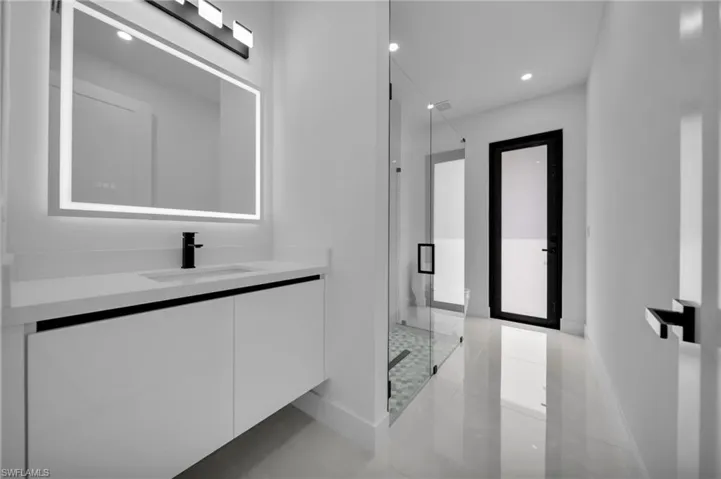 Bathroom with a stall shower, baseboards, recessed lighting, and vanity