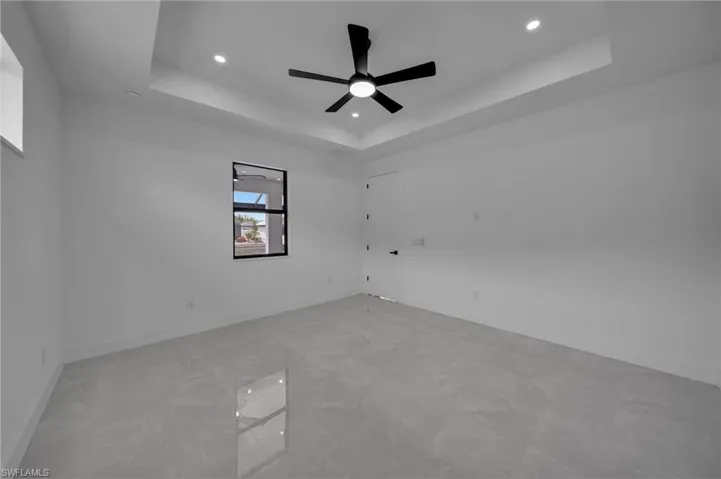 Unfurnished room with a tray ceiling, baseboards, and recessed lighting