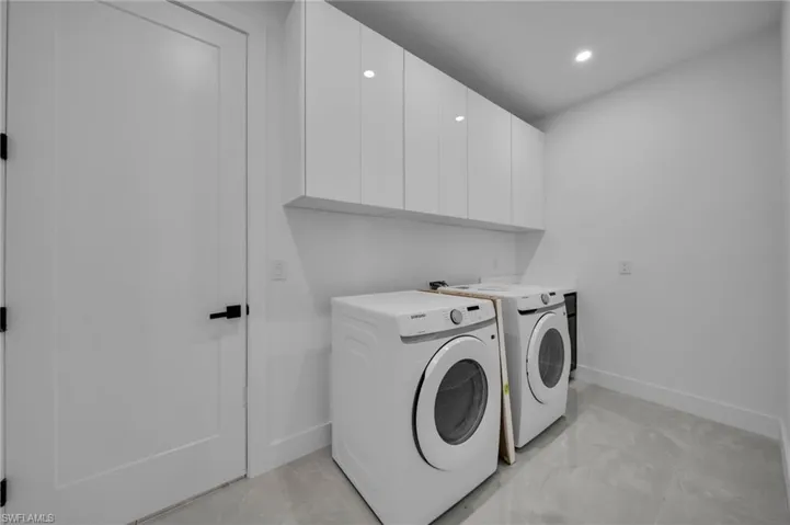 Washroom with baseboards, cabinet space, independent washer and dryer, and recessed lighting