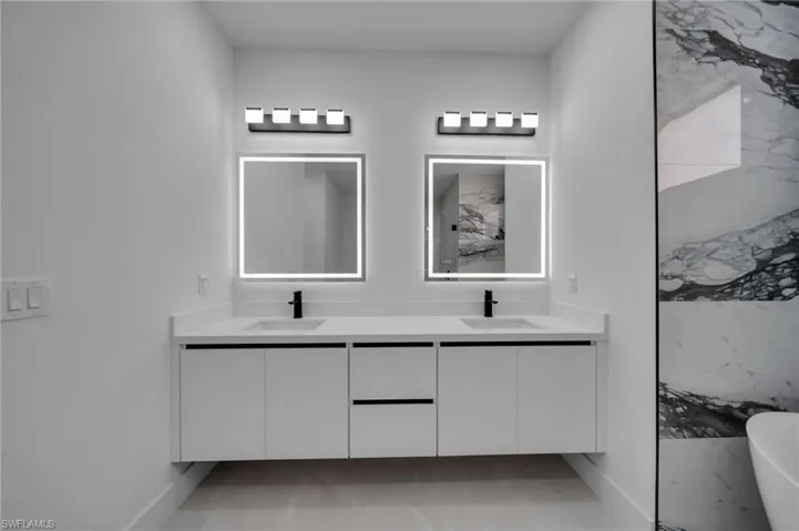Bathroom with a soaking tub, double vanity, and a sink