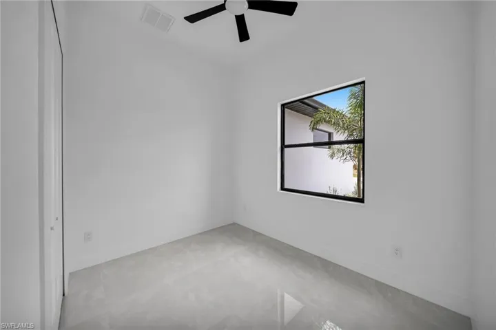 Spare room featuring baseboards, ceiling fan, and visible vents