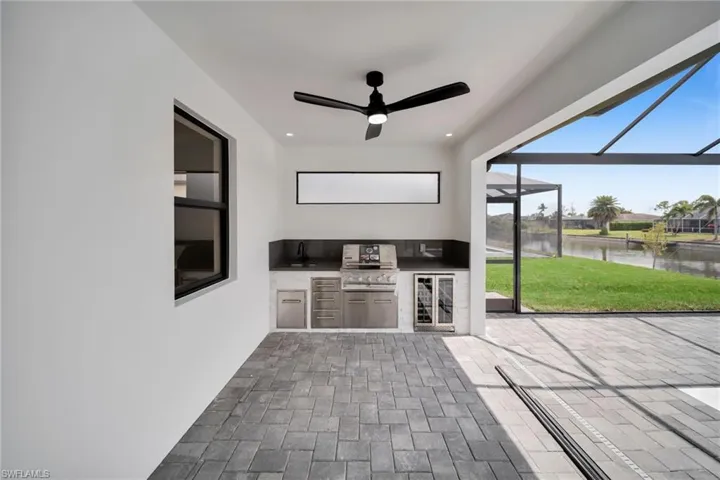 View of patio / terrace featuring glass enclosure, a water view, ceiling fan, and area for grilling