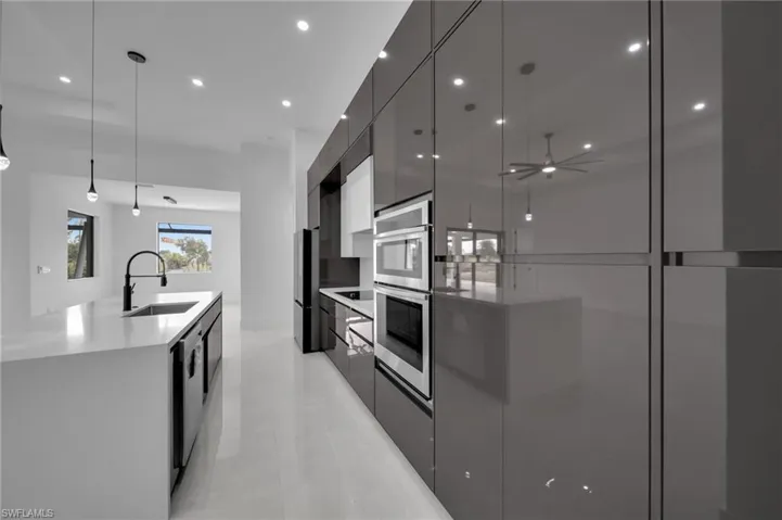 Kitchen featuring modern cabinets, recessed lighting, a large island with sink, and a sink