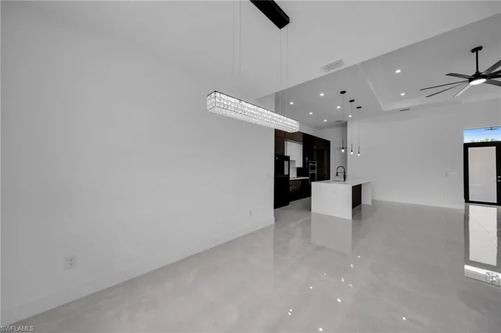 Unfurnished living room featuring visible vents, baseboards, recessed lighting, a ceiling fan, and a sink
