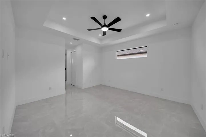 Spare room featuring baseboards, ceiling fan, recessed lighting, and a raised ceiling