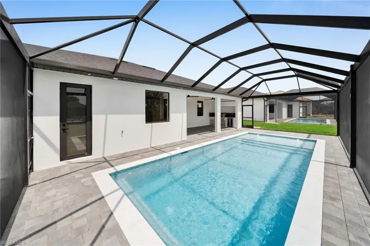 Pool featuring a patio and glass enclosure
