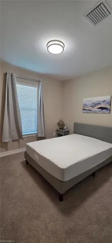 Carpeted bedroom featuring baseboards