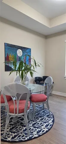 Dining space / den with wood finished floors and a raised ceiling