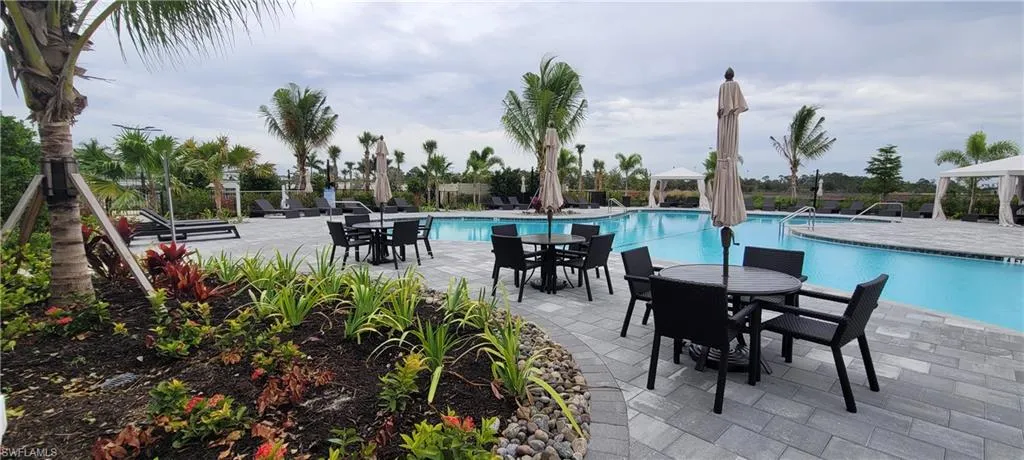 Community pool with a patio area and outdoor dining area
