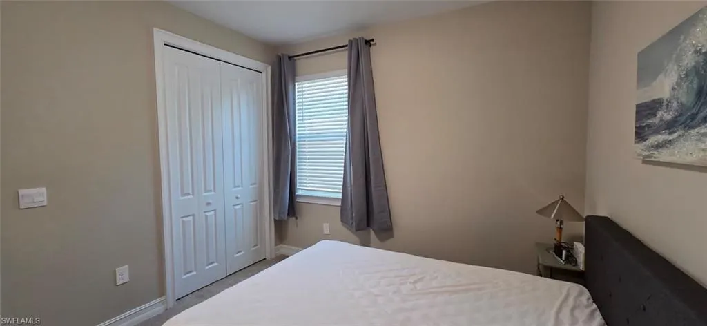 Carpeted bedroom featuring a closet and baseboards