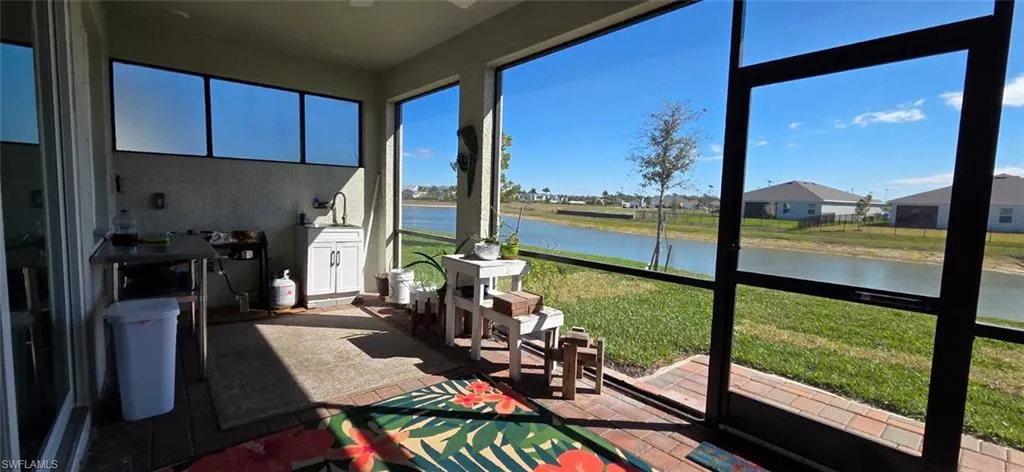 Sunroom with a water view, a residential view, and ceiling fan