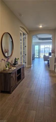 Hall with arched walkways and dark wood finished floors