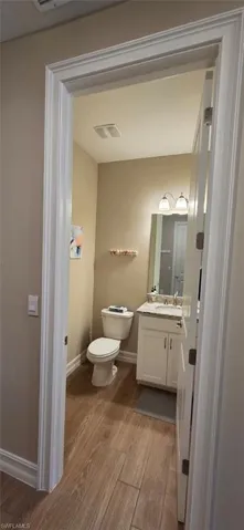 Half bath featuring dark wood-style floors and vanity