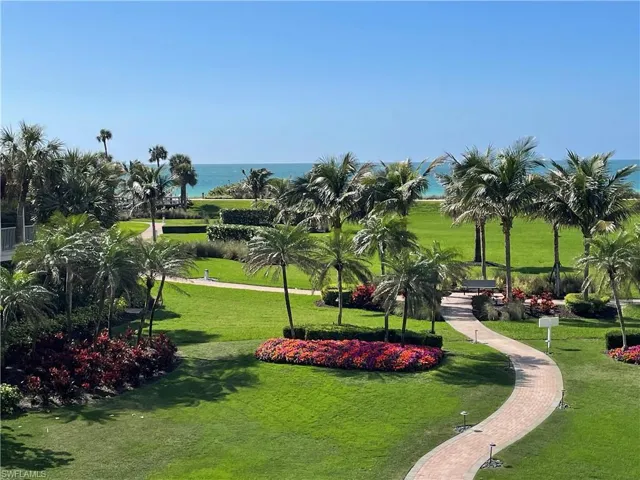 View of the beach from community patio area with sidewalk to the beachside promenade and beach