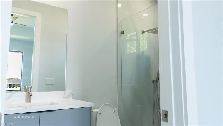Full bathroom with vanity and a stall shower