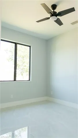 Unfurnished room with a ceiling fan and baseboards