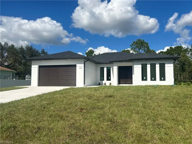 View of front of home featuring a garage and a front lawn