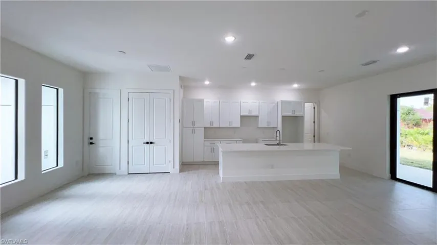 Kitchen featuring white cabinets, sink, and a kitchen island with sink