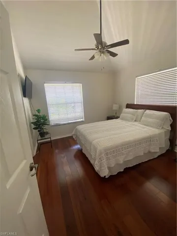 Bedroom with dark wood-style flooring and ceiling fan