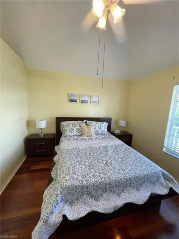 Bedroom with lofted ceiling, dark wood-type flooring, and ceiling fan