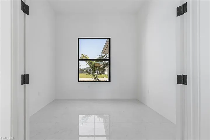 Spare room featuring marble finish floor and baseboards