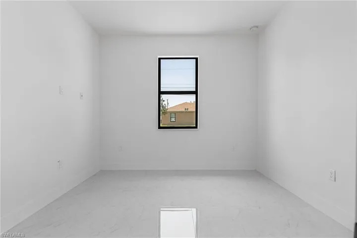 Spare room featuring baseboards and marble finish floor