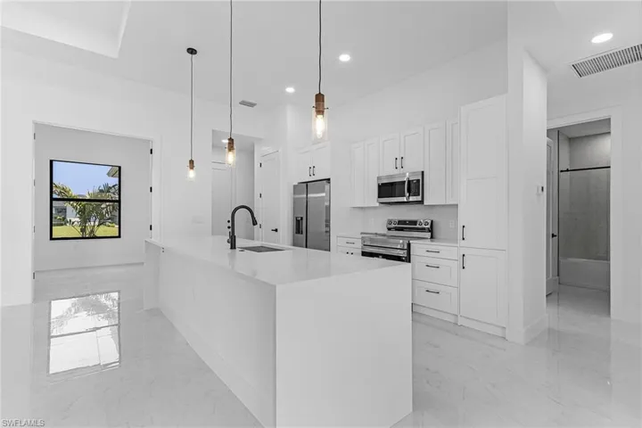 Kitchen with white cabinetry, marble finish floor, a sink, visible vents, and appliances with stainless steel finishes
