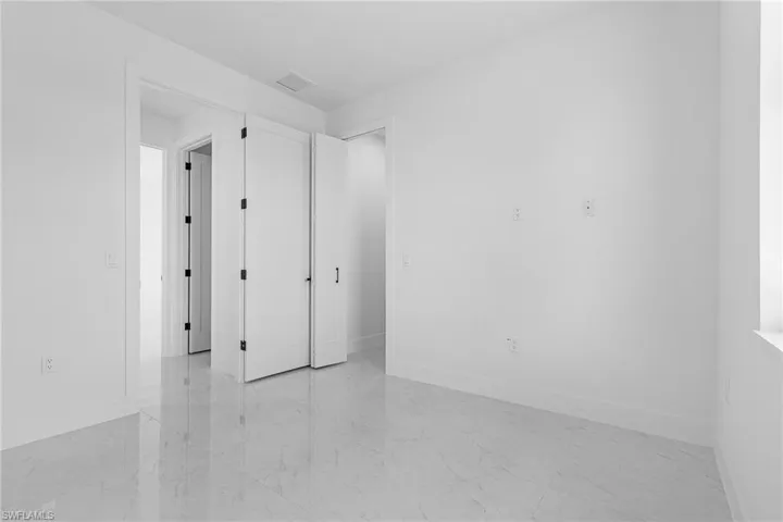 Unfurnished room featuring marble finish floor, baseboards, and visible vents