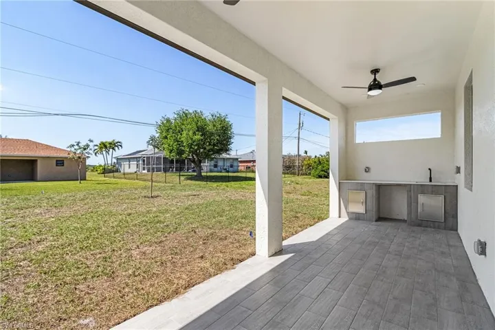 View of patio / terrace featuring fence, an outdoor kitchen, and a ceiling fan