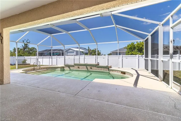 View of swimming pool featuring a fenced in pool, a patio, a fenced backyard, and glass enclosure