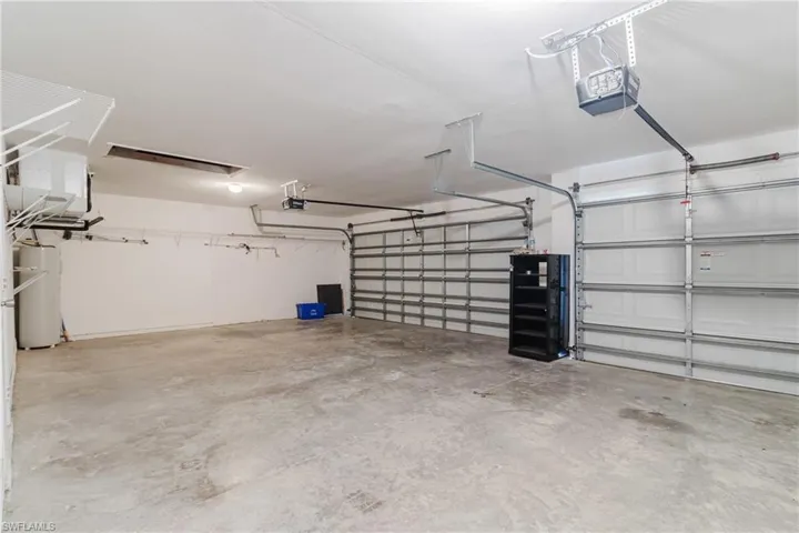 Garage featuring a garage door opener and water heater