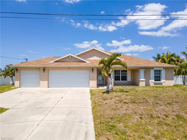 Single story home featuring a front yard, an attached garage, stucco siding, and concrete driveway
