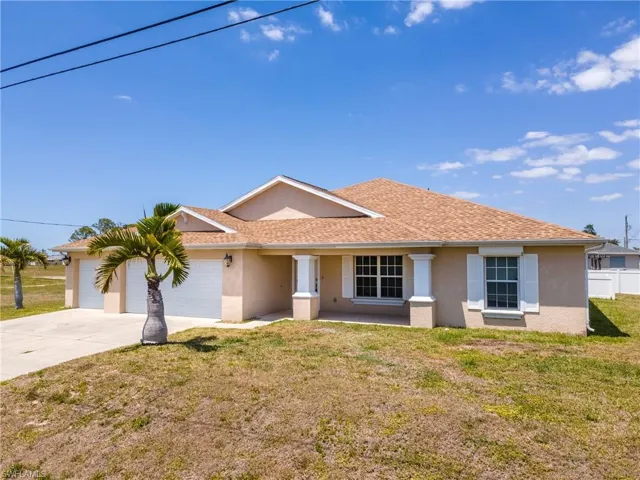 Single story home featuring stucco siding, driveway, an attached garage, a front lawn, and a shingled roof