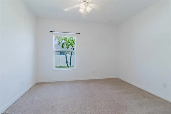 Unfurnished room featuring baseboards, a ceiling fan, and carpet flooring