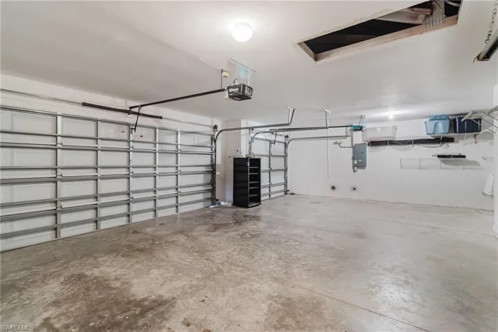 Garage with electric panel and a garage door opener