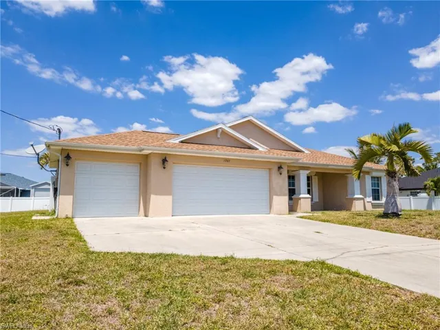 Ranch-style house featuring concrete driveway, stucco siding, fence, and an attached garage