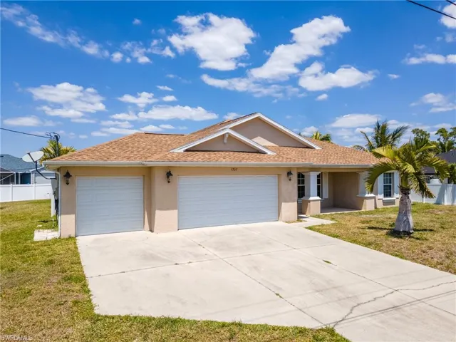Ranch-style house with concrete driveway, stucco siding, an attached garage, a front lawn, and fence