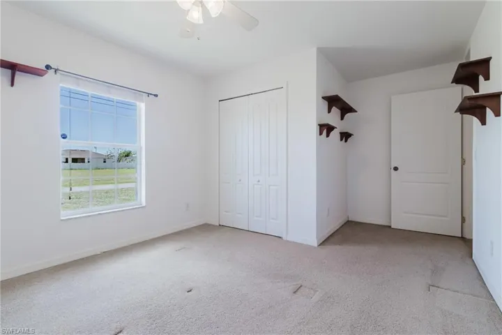 Unfurnished bedroom featuring a closet, baseboards, ceiling fan, and carpet